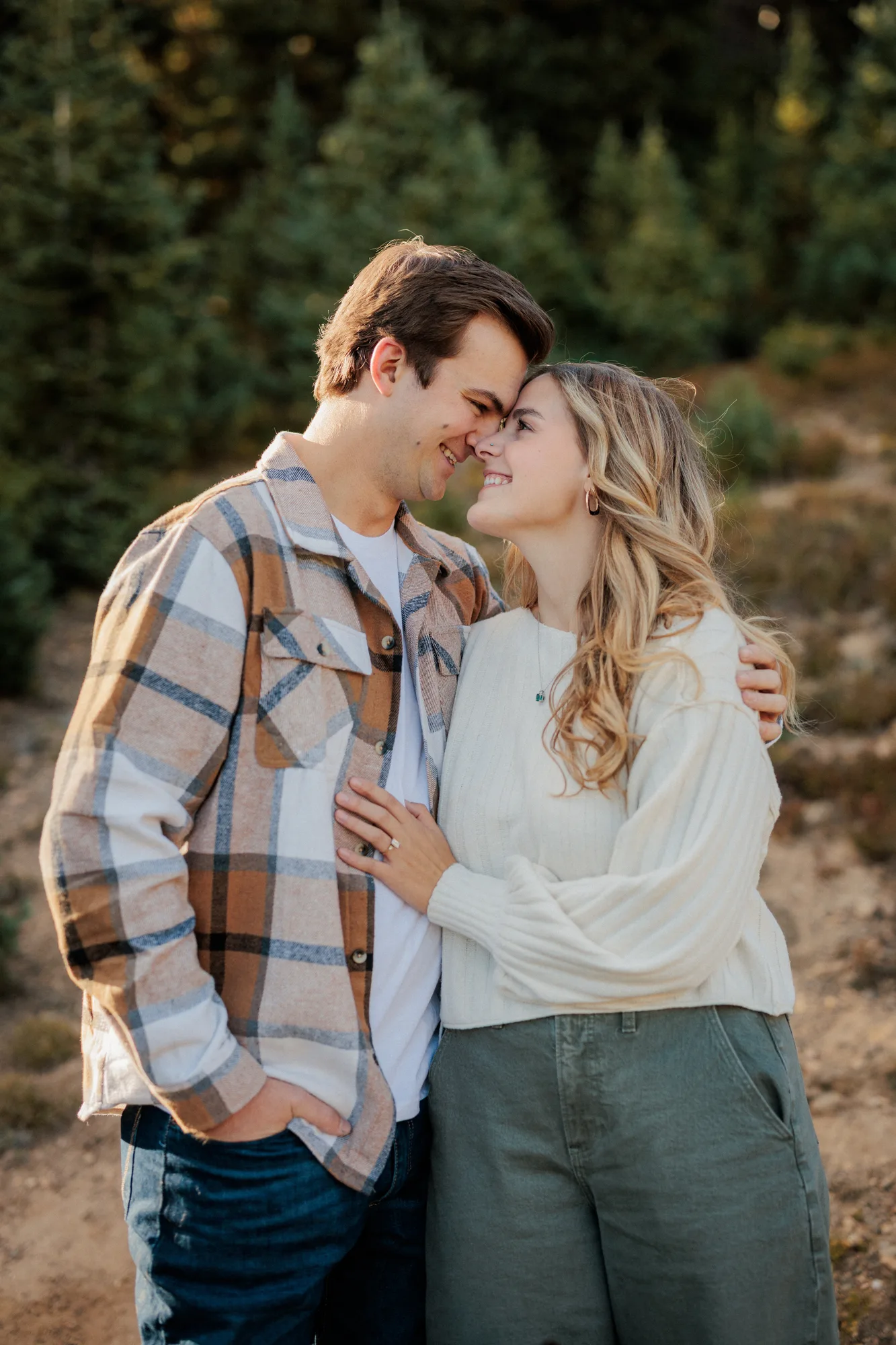 Jordan and Daelynn forehead to forehead on a mountain trail