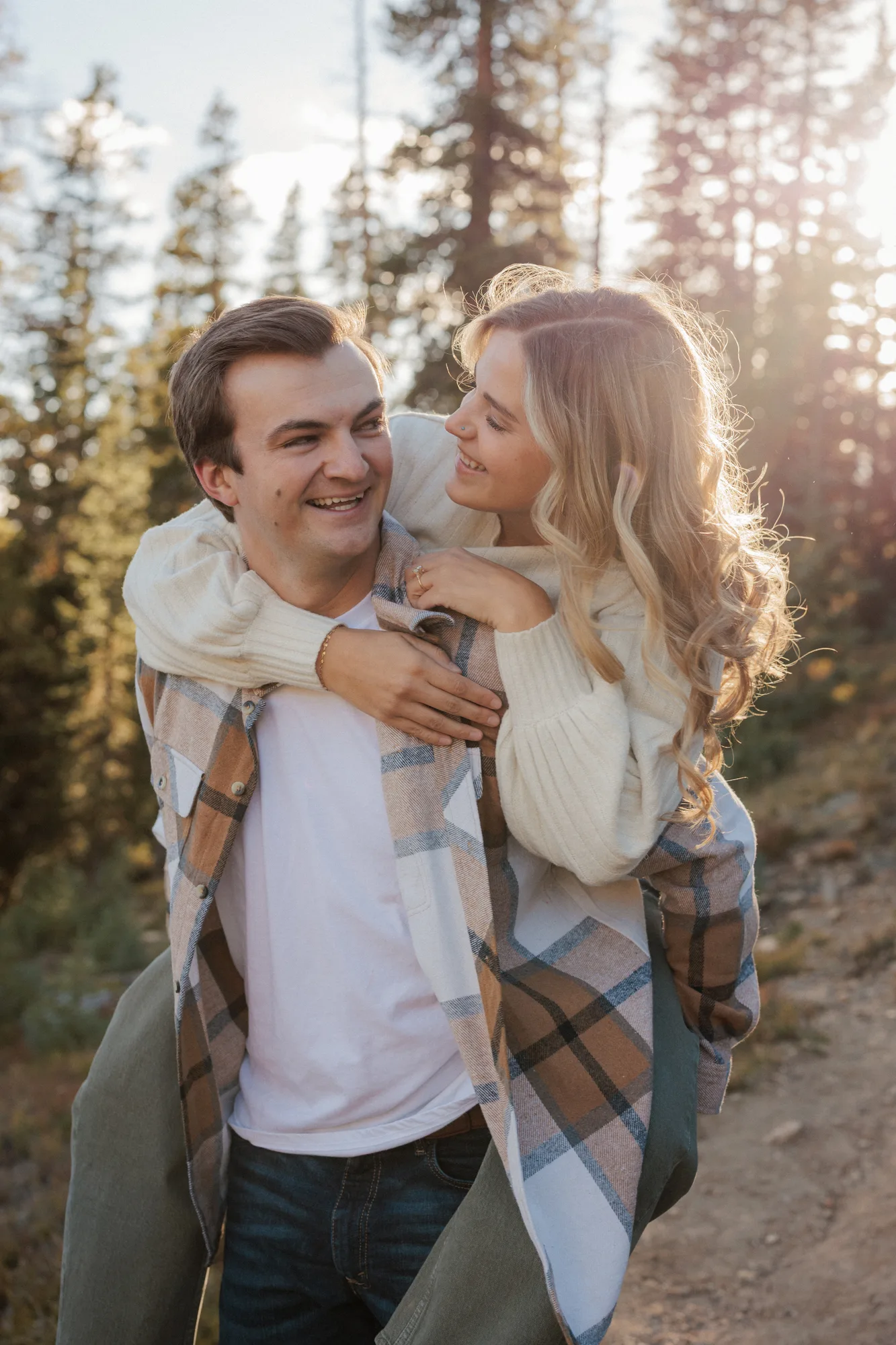 Daelynn riding piggyback on Jordan in golden light