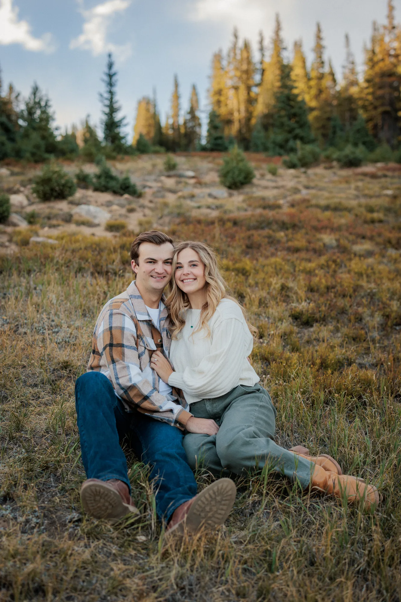 Jordan and Daelynn smiling together in the meadow grass