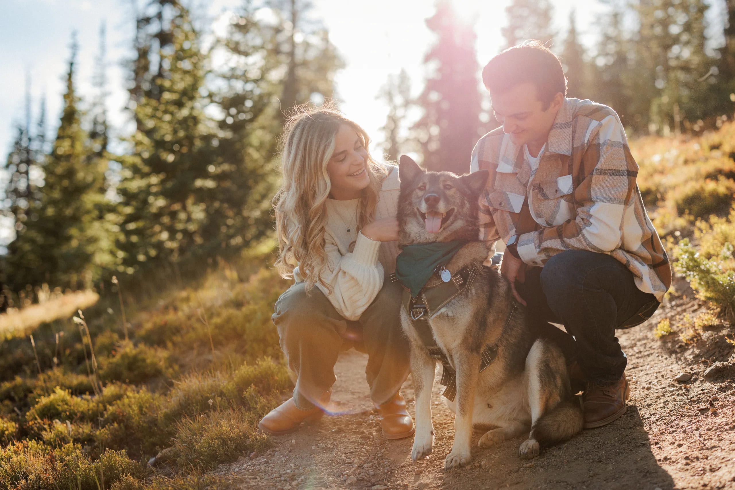 Jordan and Daelynn crouched on a mountain trail with Churchill